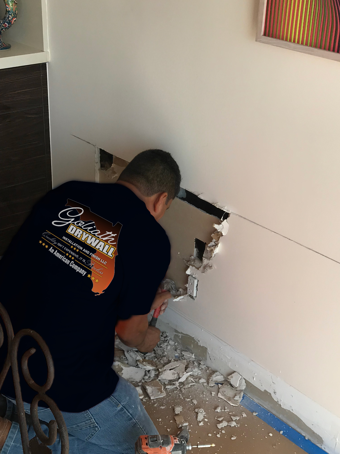 Crew member opening a damaged interior wall for repair
