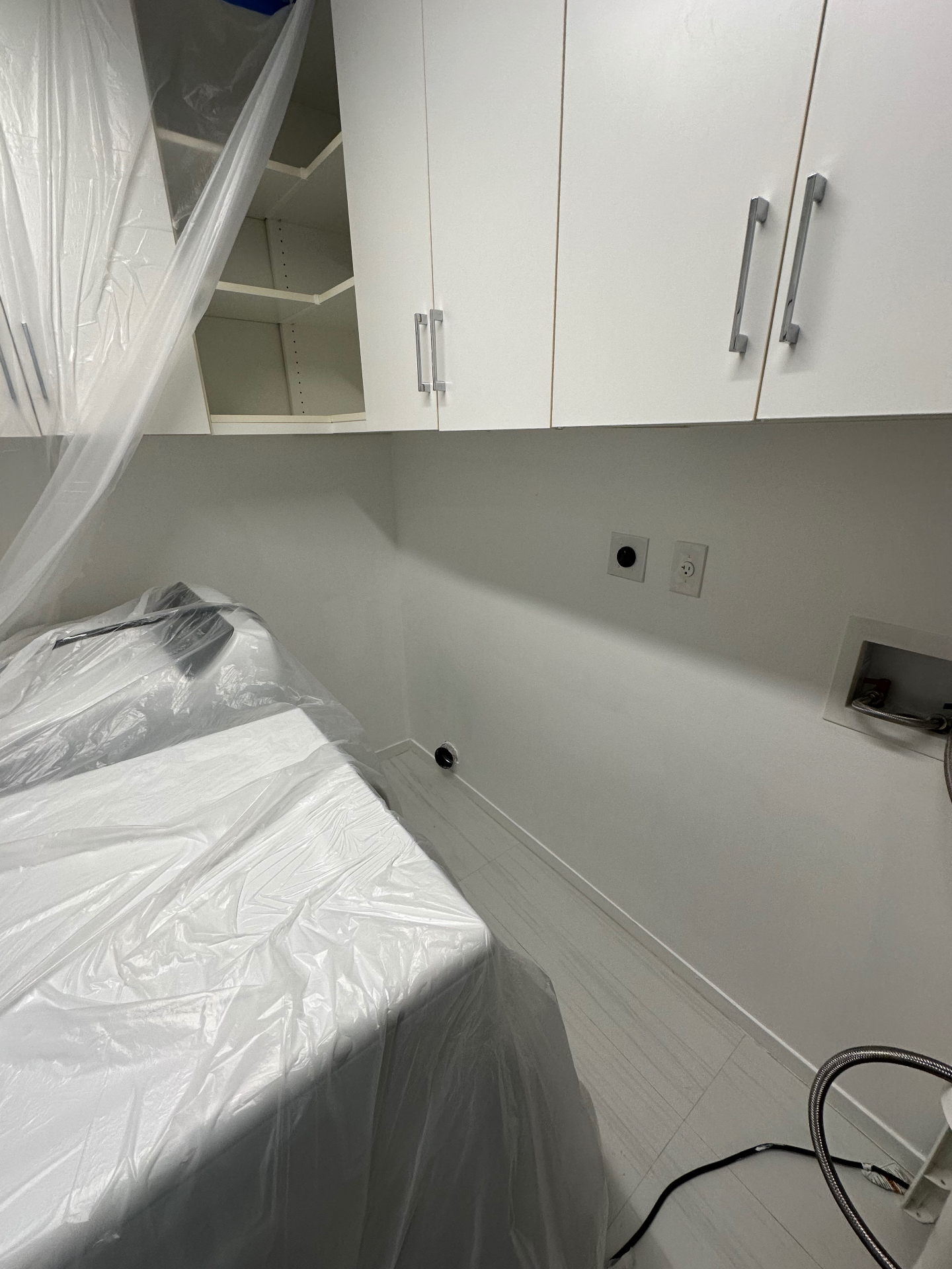 Same laundry room wall after skim coat and paint — seamless finish