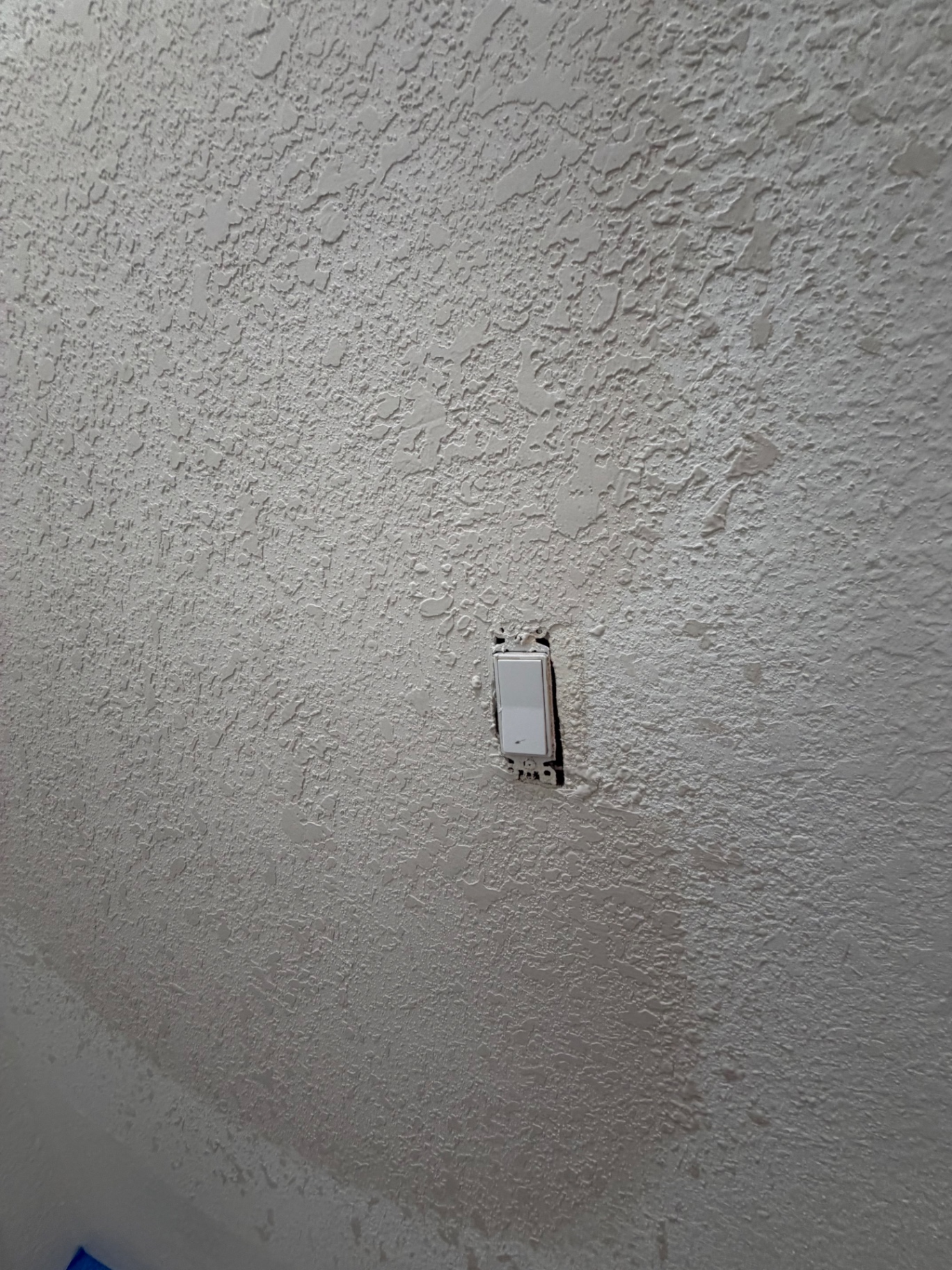 Same wall after drywall, plaster and knockdown texture match — patch is invisible
