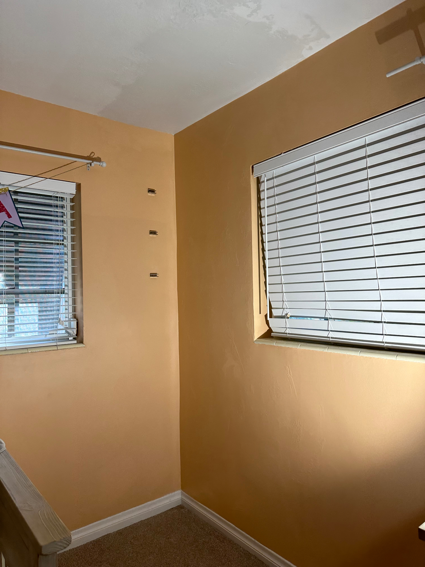 Same bedroom corner after drywall, plaster and paint — wall finished and seamless